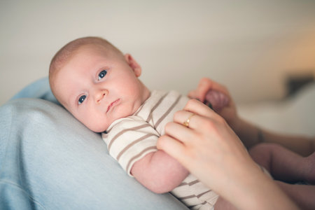 Cute small 1 month baby boy at home. Mother with little newborn infant.の写真素材