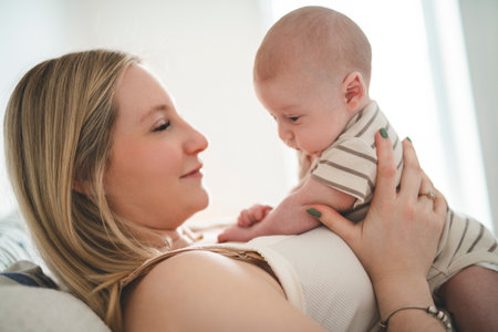 Cute small 1 month baby boy at home. Mother with little newborn infant.