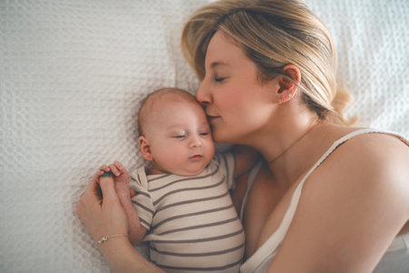 Cute small 1 month baby boy at home. Mother with little newborn infant.の写真素材