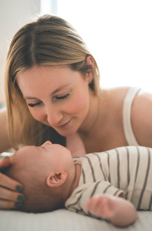 Cute small 1 month baby boy at home. Mother with little newborn infant.
