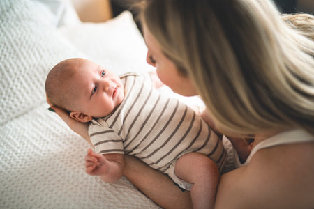 Cute small 1 month baby boy at home. Mother with little newborn infant.の写真素材