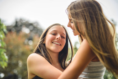Girlfriends having fun outdoors togerher wearing urban clothesの写真素材