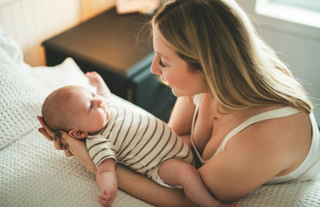 Cute small 1 month baby boy at home. Mother with little newborn infant.の写真素材