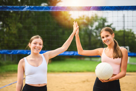 High five, two women play beach volleyball in summerの写真素材
