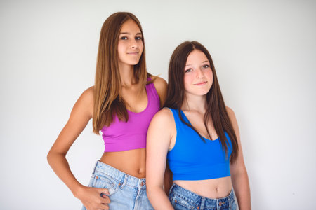 portrait of two 14 years old best friends girls close to a wall with color shirtの写真素材