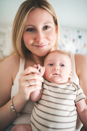 Cute small 1 month baby boy at home. Mother with little newborn infant.の写真素材