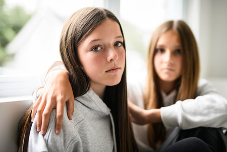 Teen girl sit on sofa wearing hoodiesの写真素材