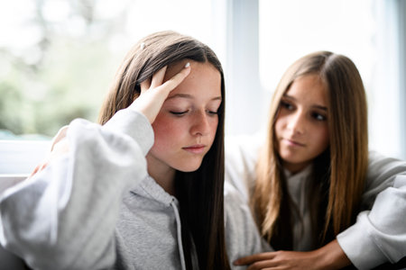 Teen girl sit on sofa wearing hoodiesの写真素材