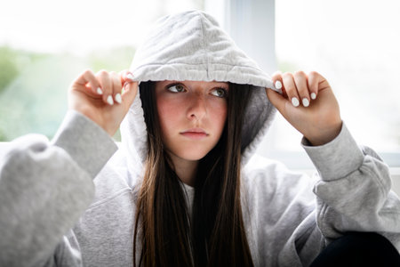 Teen girl on white studio wearing hoodiesの写真素材