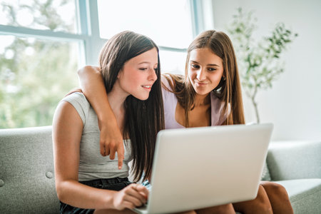 Two teen using laptop in the living room. Friends, friendship, time togetherの写真素材