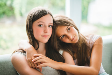 Two girls having fun together on white studioの写真素材