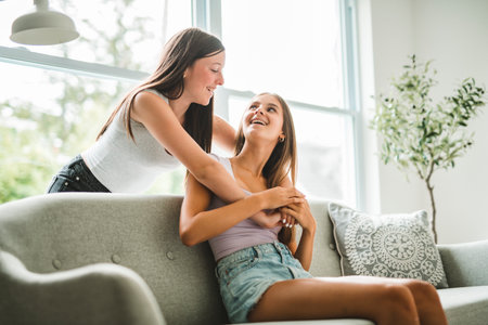 Two girls having fun together on white studioの写真素材