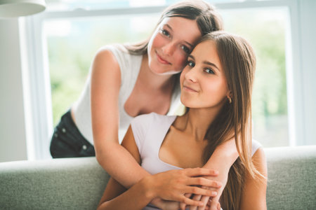 Two girls having fun together on white studioの写真素材