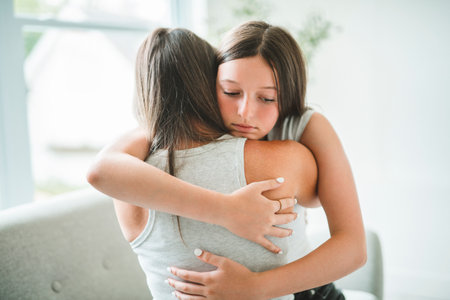 Worried teen with mother consoling share problem with someone close conceptの写真素材