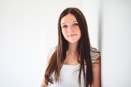 portrait of a 14 years old teen girl close to a windowの写真素材