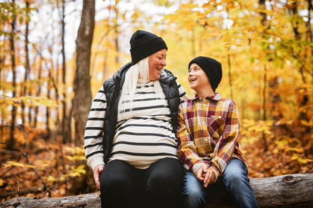 Joyful pregnant mother and his little boy. mother and child have fun on nature outdoors at autumn...