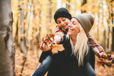 Joyful mother and his little boy. mother and child have fun on nature outdoors at autumn park.