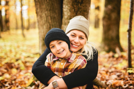 Joyful mother and her little boy. mother and child have fun on nature outdoors at autumn park.の写真素材