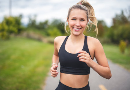 Front view of a happy runner teen doing joggingの写真素材