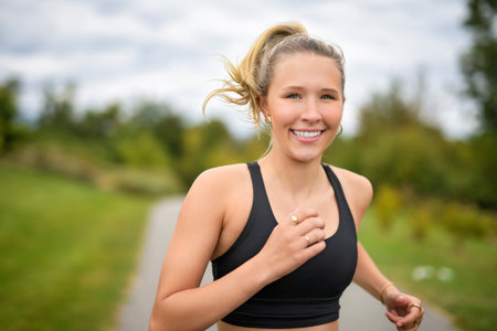 Front view of a happy runner teen doing joggingの写真素材