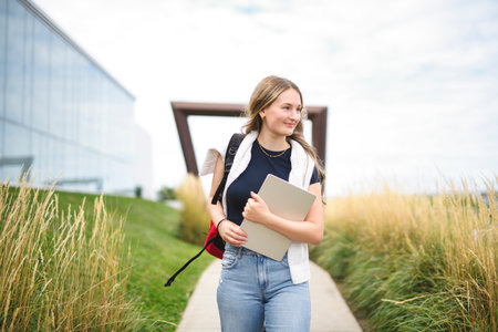 Young girl high school or college student She is on her way to class near university buildingの写真素材