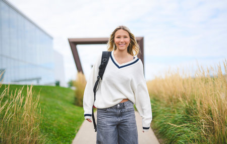 Young girl high school or college student She is on her way to class near university building