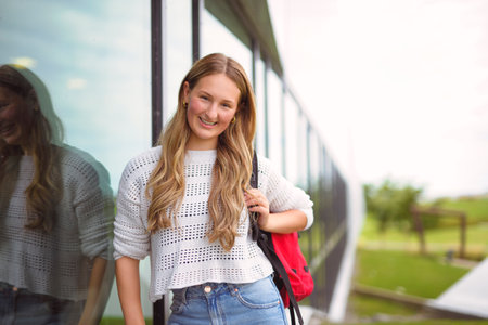Young girl high school or college student She is on her way to class near university buildingの写真素材