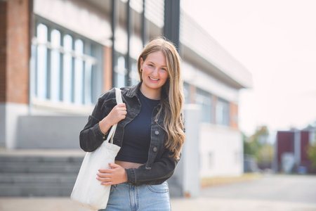 Young girl high school or college student She is on her way to class near university building