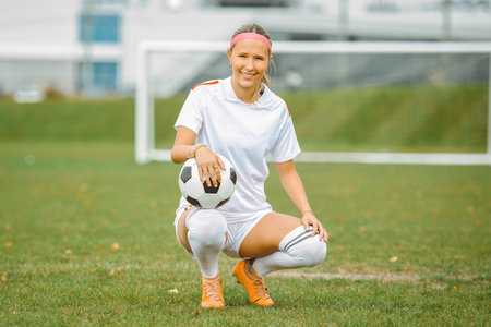 motivation soccer player with a football in a sport uniform wearing in whiteの写真素材