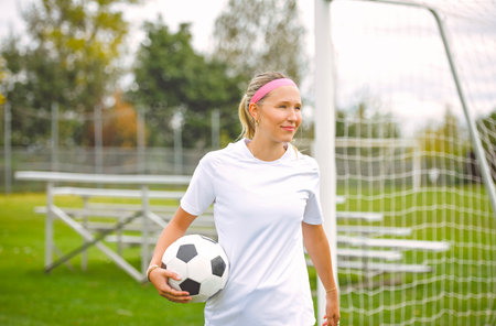 motivation soccer player with a football in a sport uniform wearing in whiteの写真素材