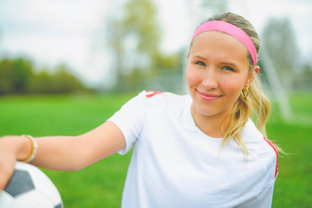 motivation soccer player with a football in a sport uniform wearing in whiteの写真素材