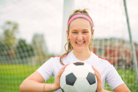 motivation soccer player with a football in a sport uniform wearing in whiteの写真素材