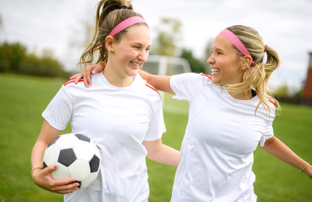 two soccer player friends with a football in a sport uniform wearing in whiteの写真素材