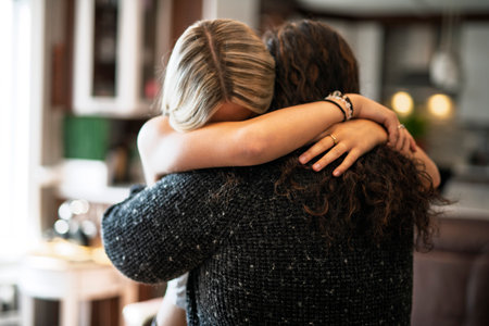 Compassionate mother comforting depressed sad teen girl, hugging daughter with loveの写真素材