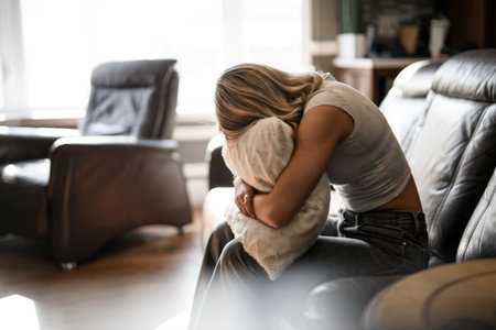 teen Girl sitting on a couch at homeの写真素材