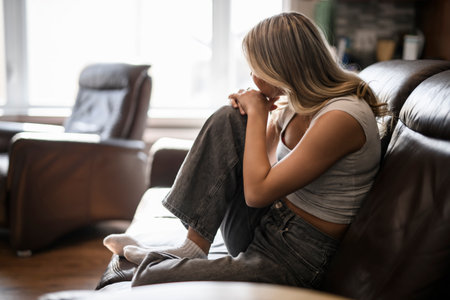 sad and stress teen sit on sofa at homeの写真素材