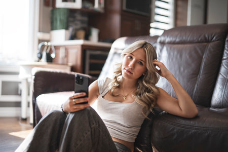 teen Girl sitting on a couch at homeの写真素材