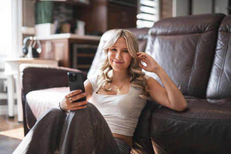 teen Girl sitting on a couch at homeの写真素材