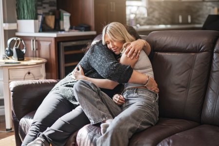 Compassionate mother comforting depressed sad teen girl, hugging daughter with loveの写真素材