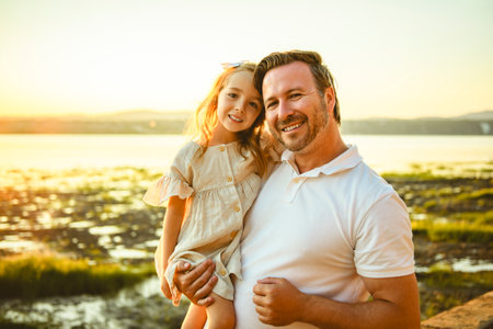 happy child girl and father are playing in field.の写真素材