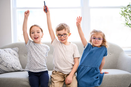 Portrait of a group of children sitting on a sofa at home.