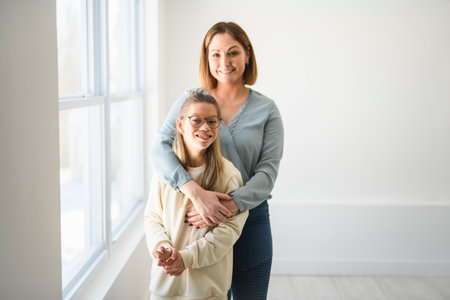 Portrait of disabled girl smiling at camera with her motherの写真素材