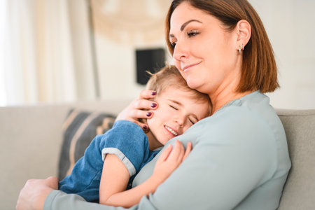Happy mom and adult daughter woman having fun at home, hugging with heads touch.の写真素材