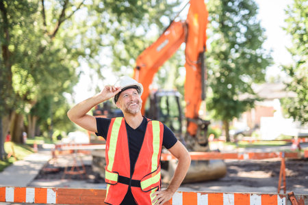 caucasian engineer with white helmet at work and having a mechanical shovel on the back