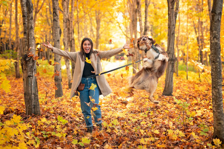 Loving woman with her shepherd Australian on fall season