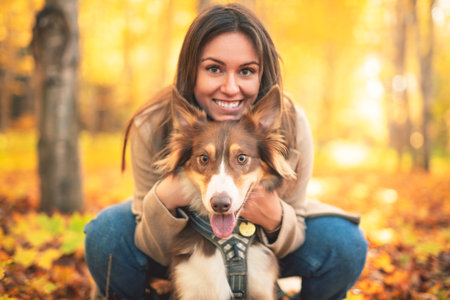 Loving woman with her shepherd Australian on fall seasonの写真素材