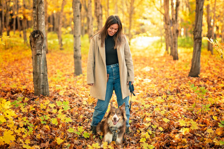 Loving woman with her shepherd Australian on fall seasonの写真素材
