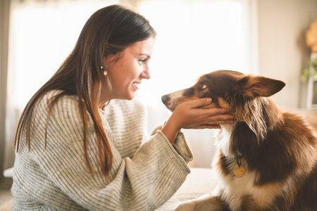 woman with cute fluffy dog at home in living roomの写真素材