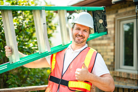 inspector or engineer with ladder checking the building structure and house roof specifications.の写真素材