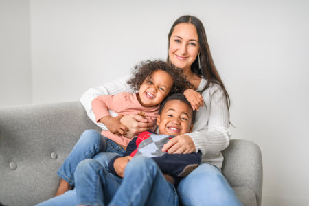 family with boy and girl child posing on photo shooting, sitting on couchの写真素材